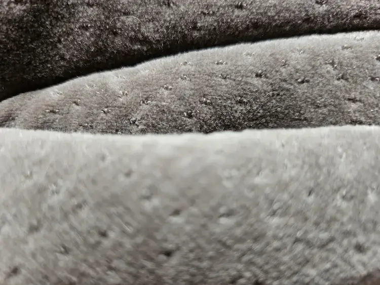 Gros plan sur la texture micro-perforée du masque Tempur avec couture diagonale et mousse viscoélastique visible