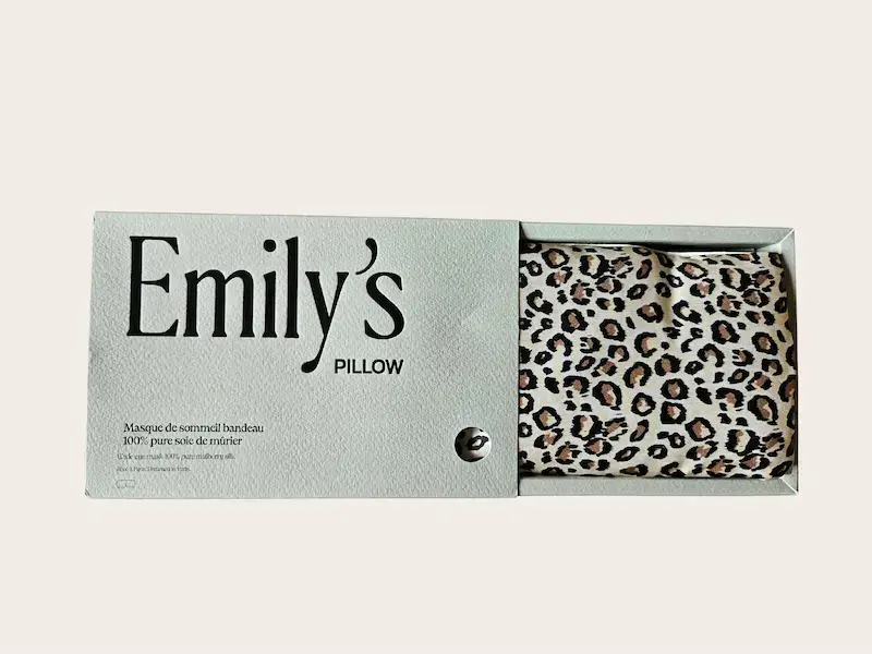 Boîte Emily’s Pillow avec le bandeau en soie plié à l’intérieur, emballage protégé par un film plastique.