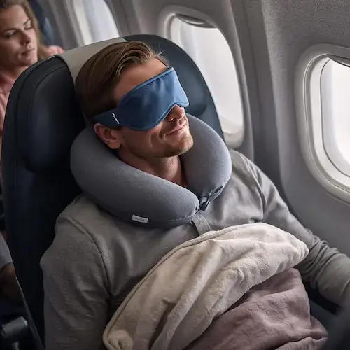 Masque de sommeil pour voyager en avion porté par un passager afin de bloquer la lumière et mieux dormir en cabine.