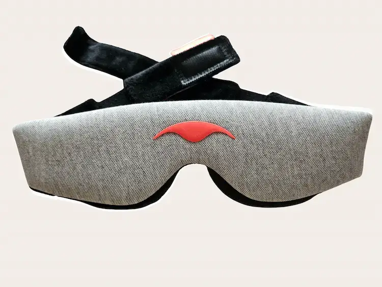 Vue frontale extérieure du Manta Sleep Mask montrant le tissu Modal gris, le logo coral signature et le système de bande avec velcro noir