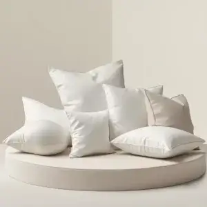 Meilleurs oreillers Dodo : comparatif des modèles ergonomiques et mémoire de forme Sélection de plusieurs oreillers blancs élégants disposés sur un socle beige clair pour illustrer un comparatif d’oreillers Dodo